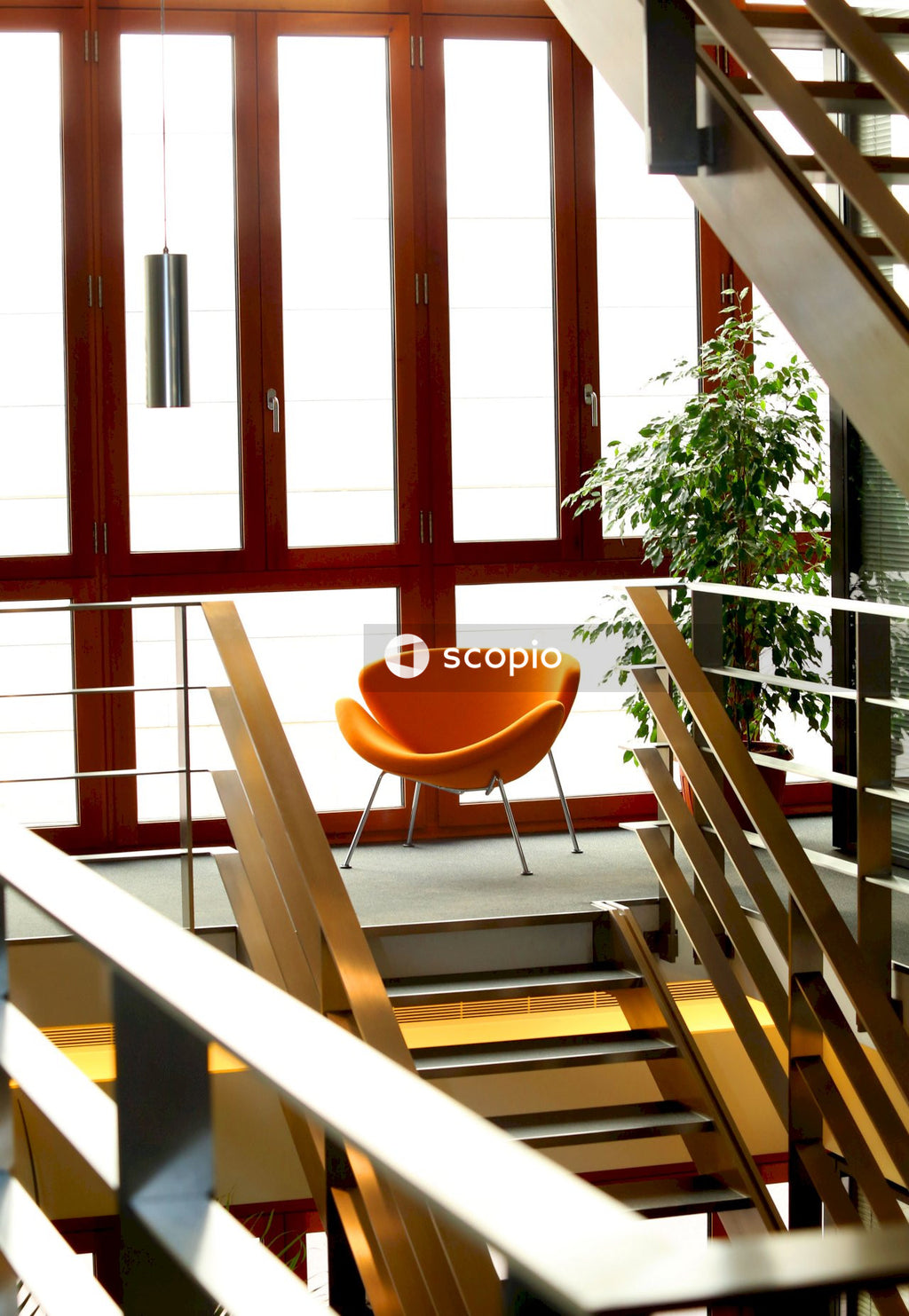 Orange chair beside indoor wooden stairs
