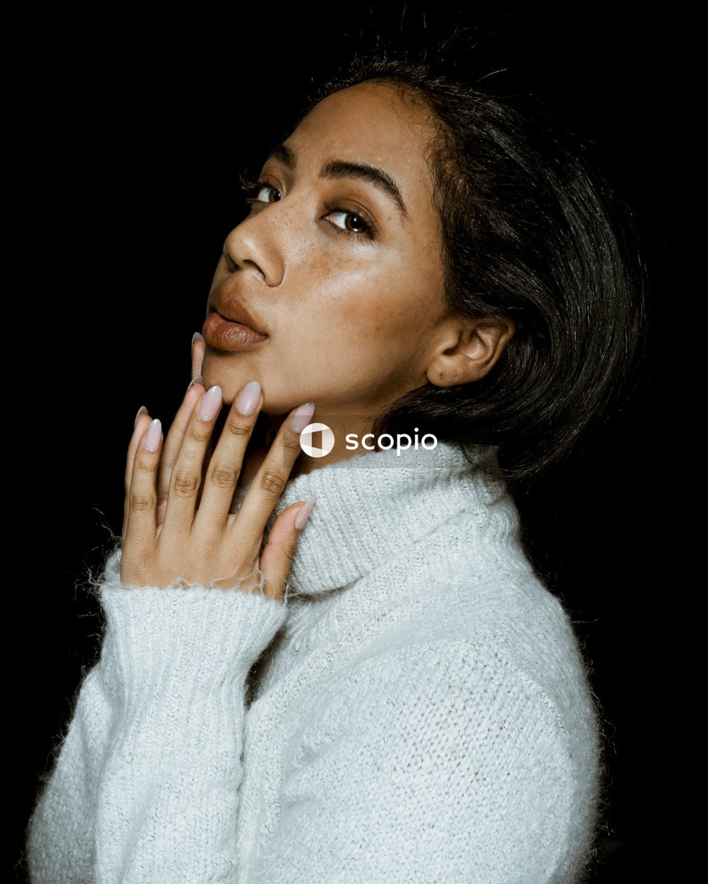 Woman in white sweater covering her face