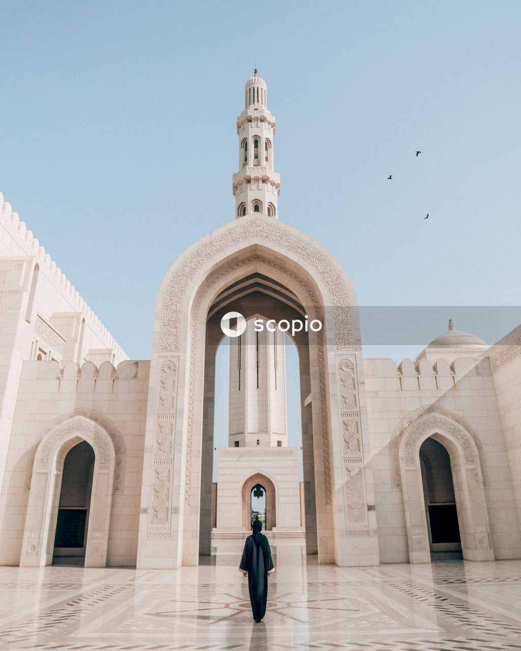 Woman in a black Abaya standing in Sultan Qaboos Grand Mosque in Muscat