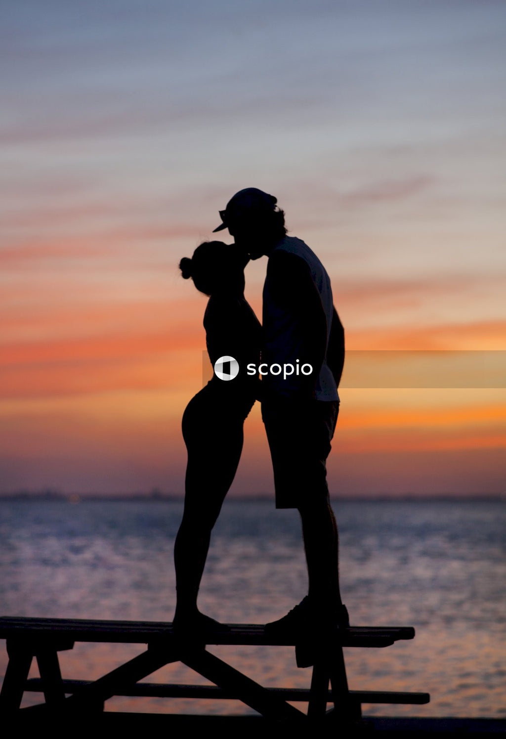 Silhouette of man and woman kissing during sunset