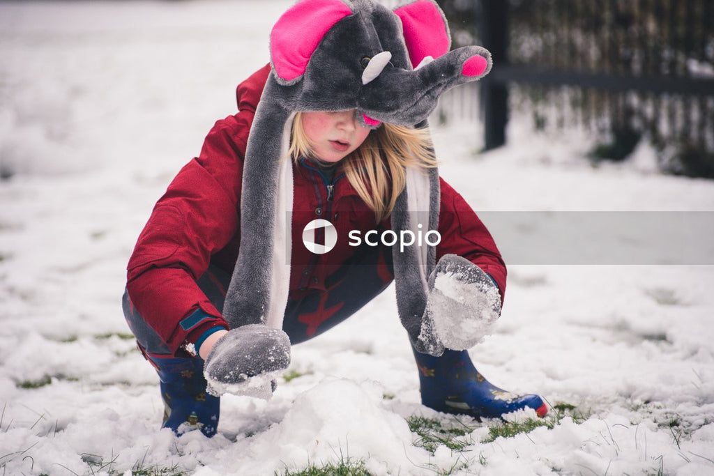 Child in Red Winter Clothes Enjoying The Season at Fullest