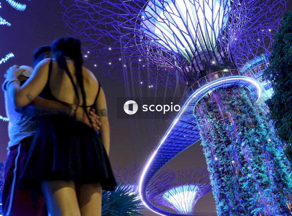 Couple standing under Supertree Grove at night in Singapore