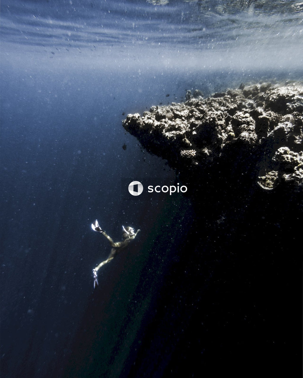 Aerial view of white and black rock formation on body of water