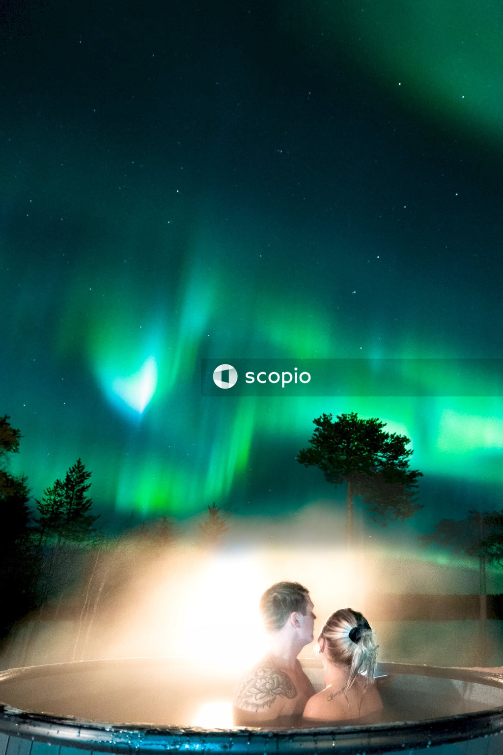 Couple at jacuzzi under aurora lights