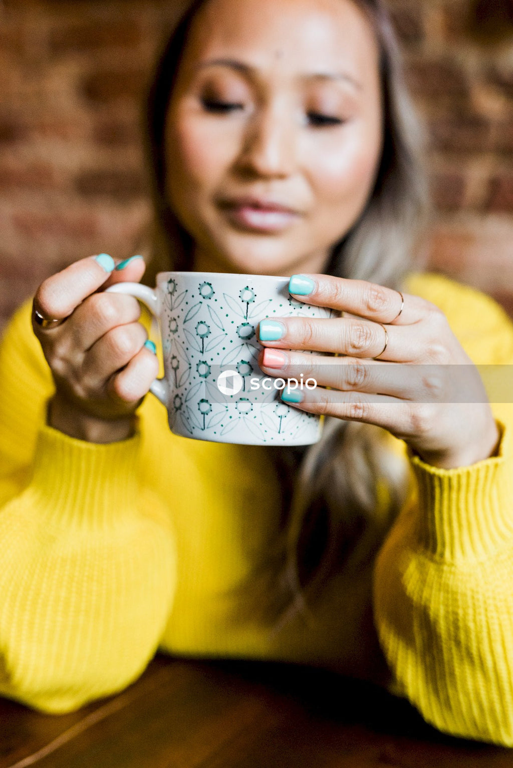 Woman in yellow sweater holding mug