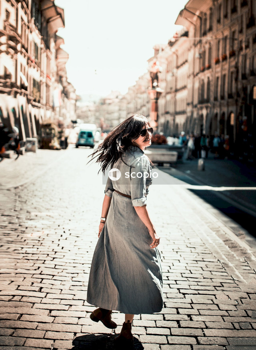 Woman in gray dress walking on sidewalk