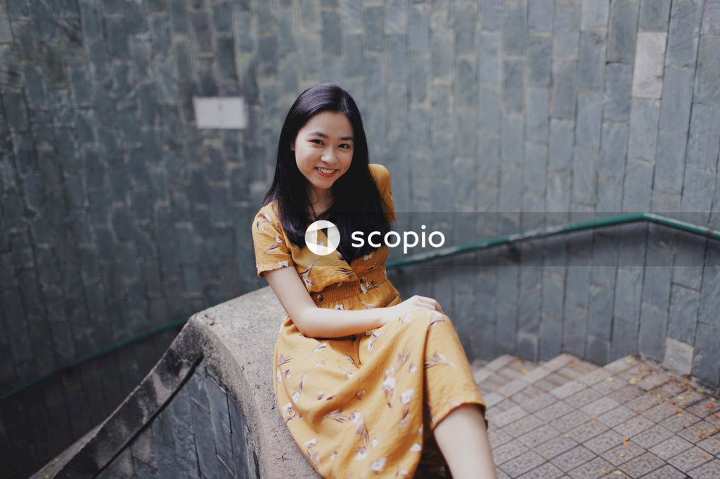 Woman in orange dress sitting on stairs