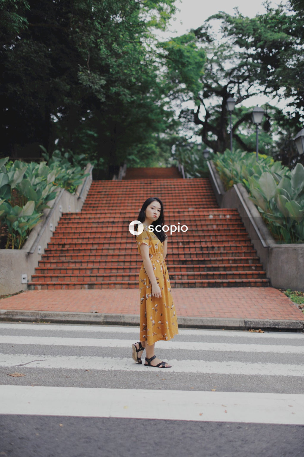 Asian woman in orange dress standing on stairs