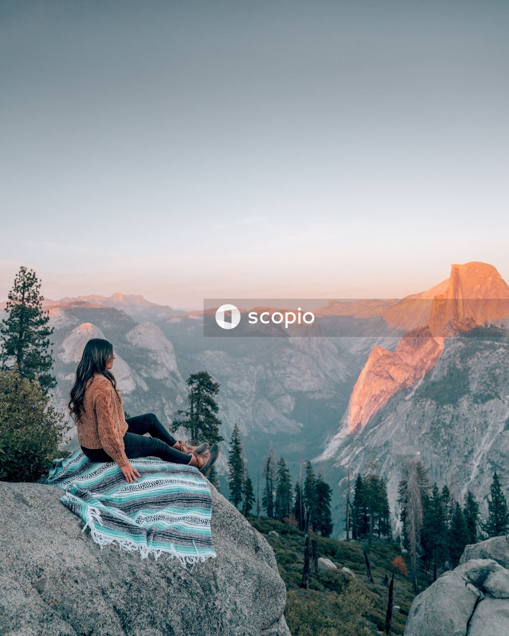 Woman in black long sleeve shirt sitting on rock formation
