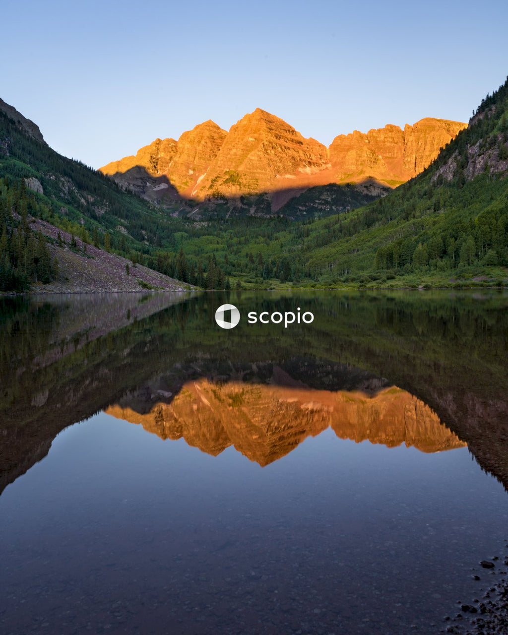 Green and brown mountains beside lake