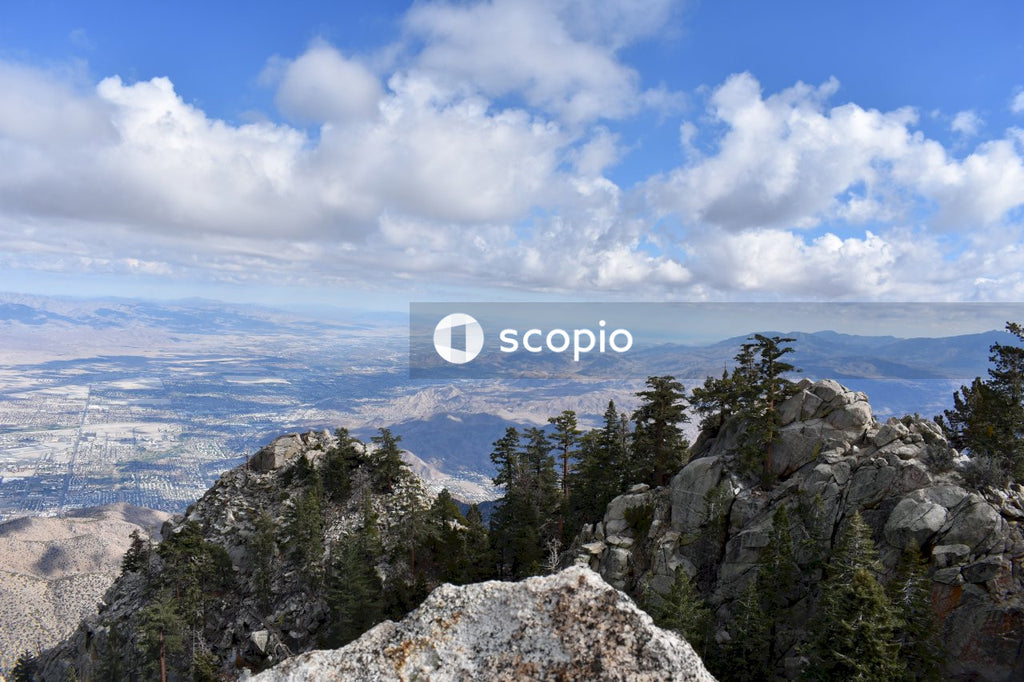 Green trees on rocky mountain under blue sky
