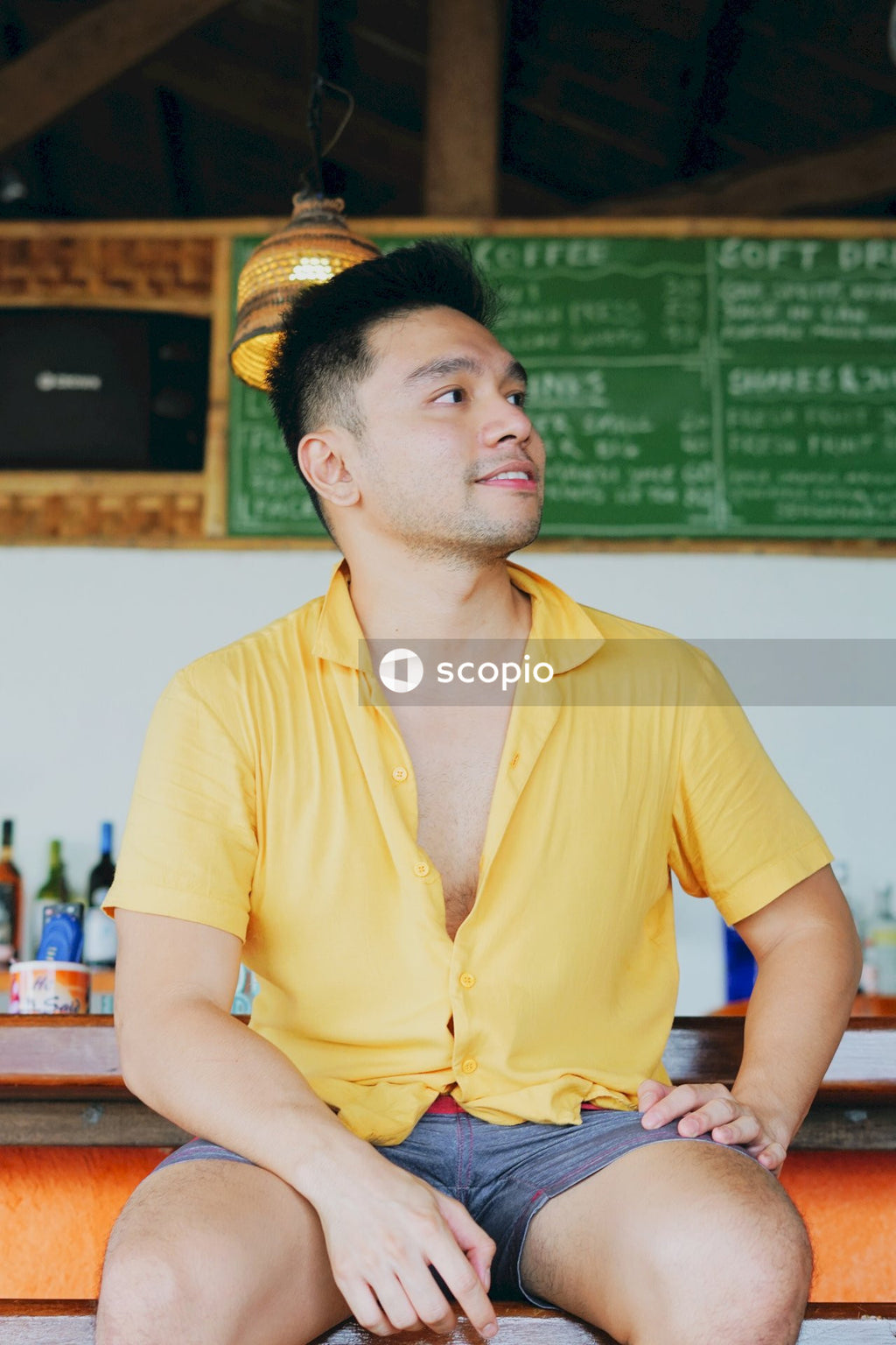 Man in yellow polo shirt sitting on a chair