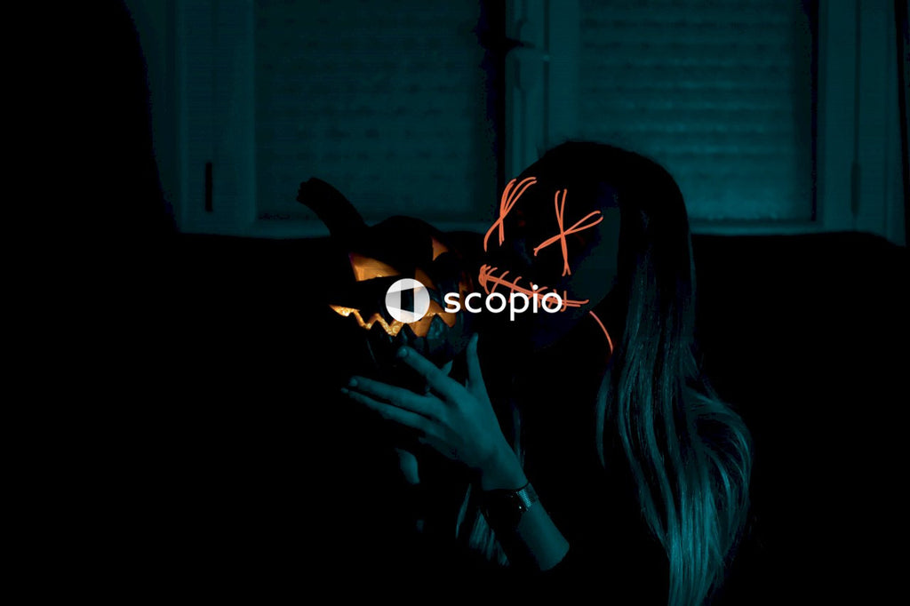 Woman with scary pumpkin mask holding a Halloween pumpkin