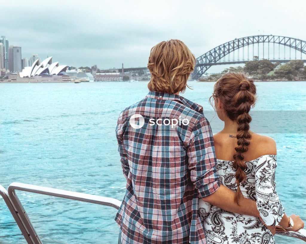Man and woman standing on oat looking at body of water