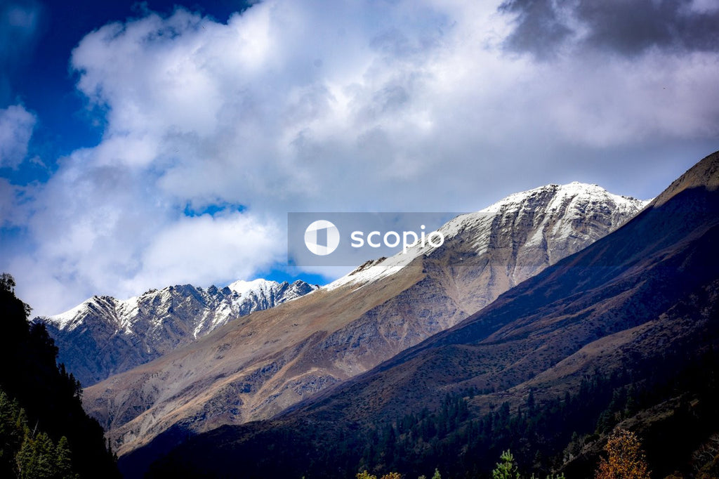 Snow covered mountain under cloudy sky