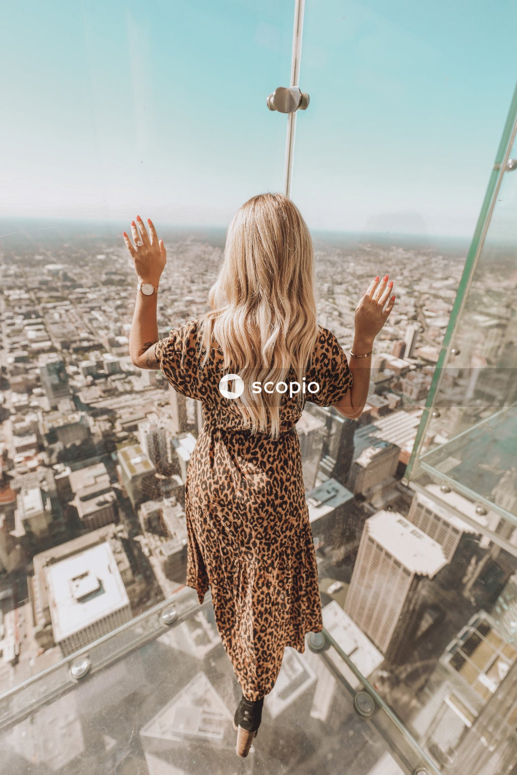 Woman looking at the city through glass window