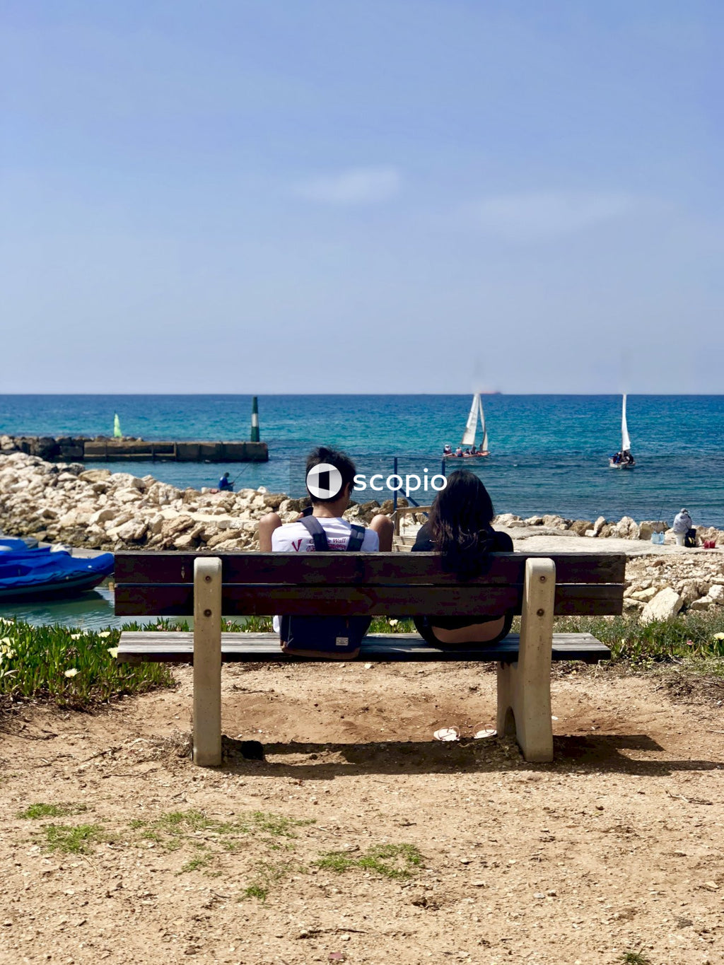 Couple sitting on bench front of sea