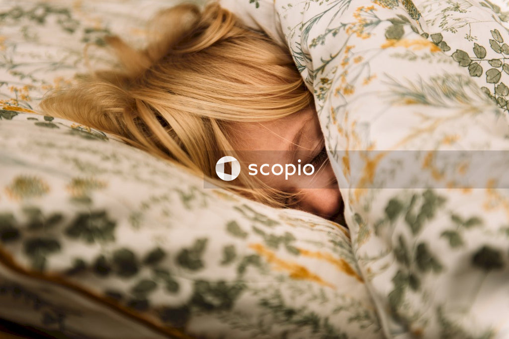 Blonde haired child lying on floral pillow