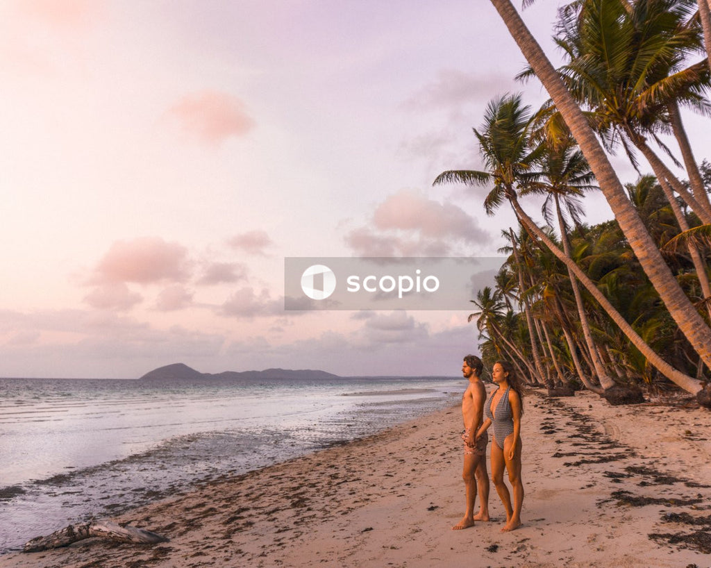 Man and woman in swimsuits standing on seashore