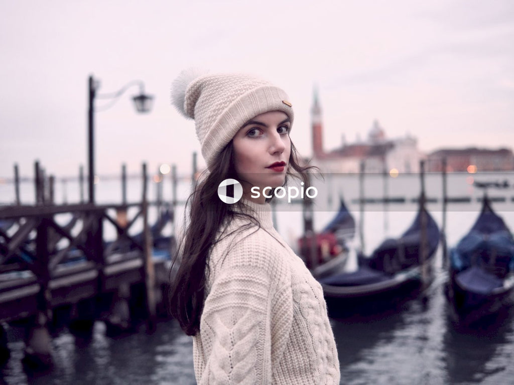Young woman with red lipsticks and knit cap standing outdoor in Venice, Italy