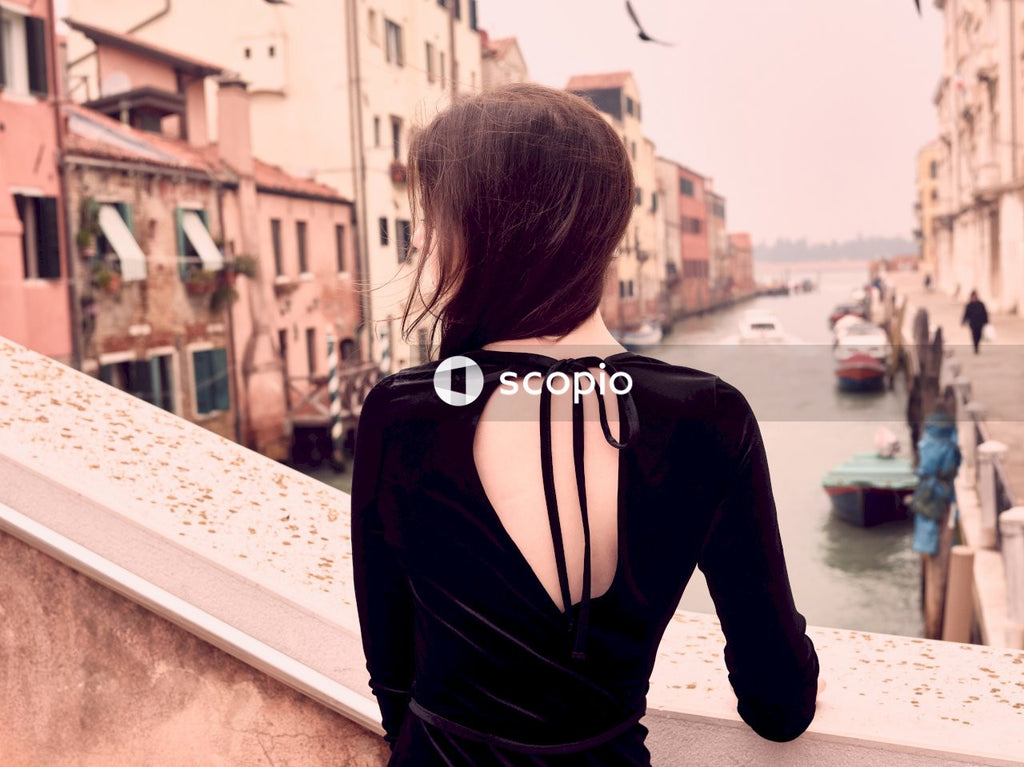 Back view of young woman standing beside banister outdoor