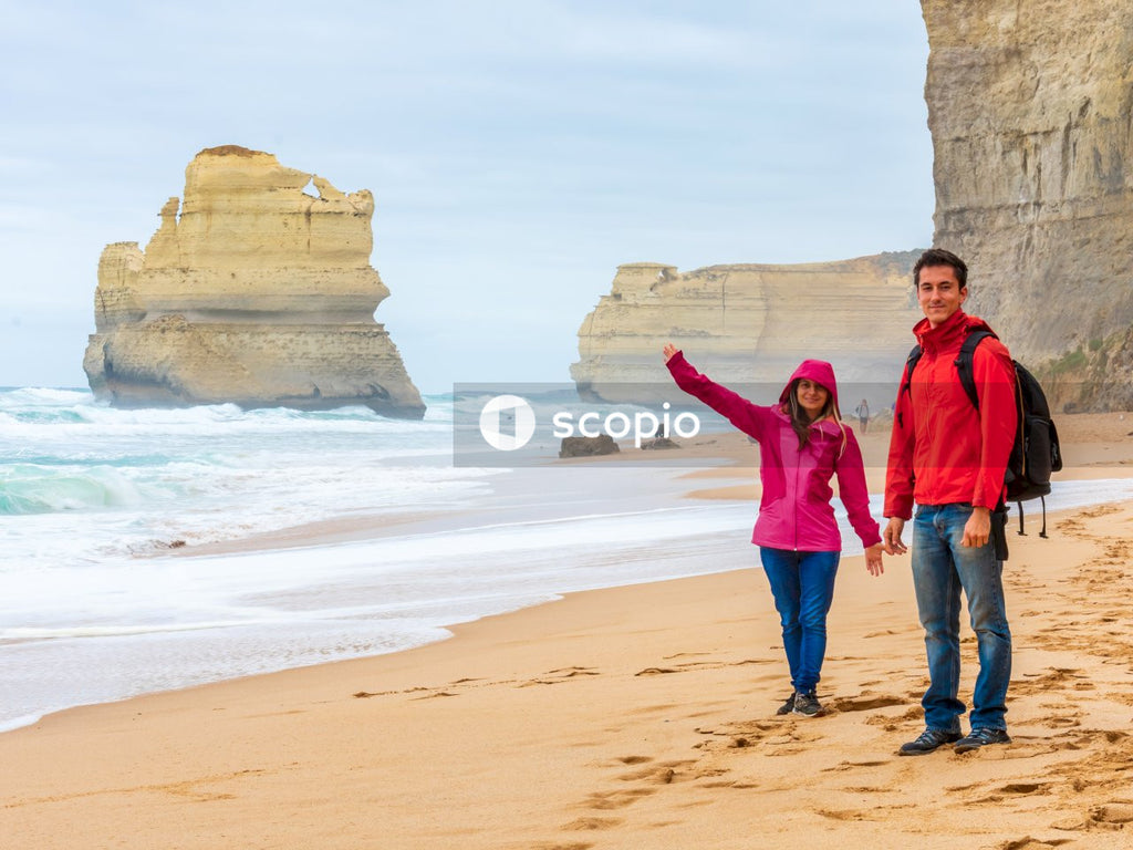 Man and a woman in raincoats at a beach