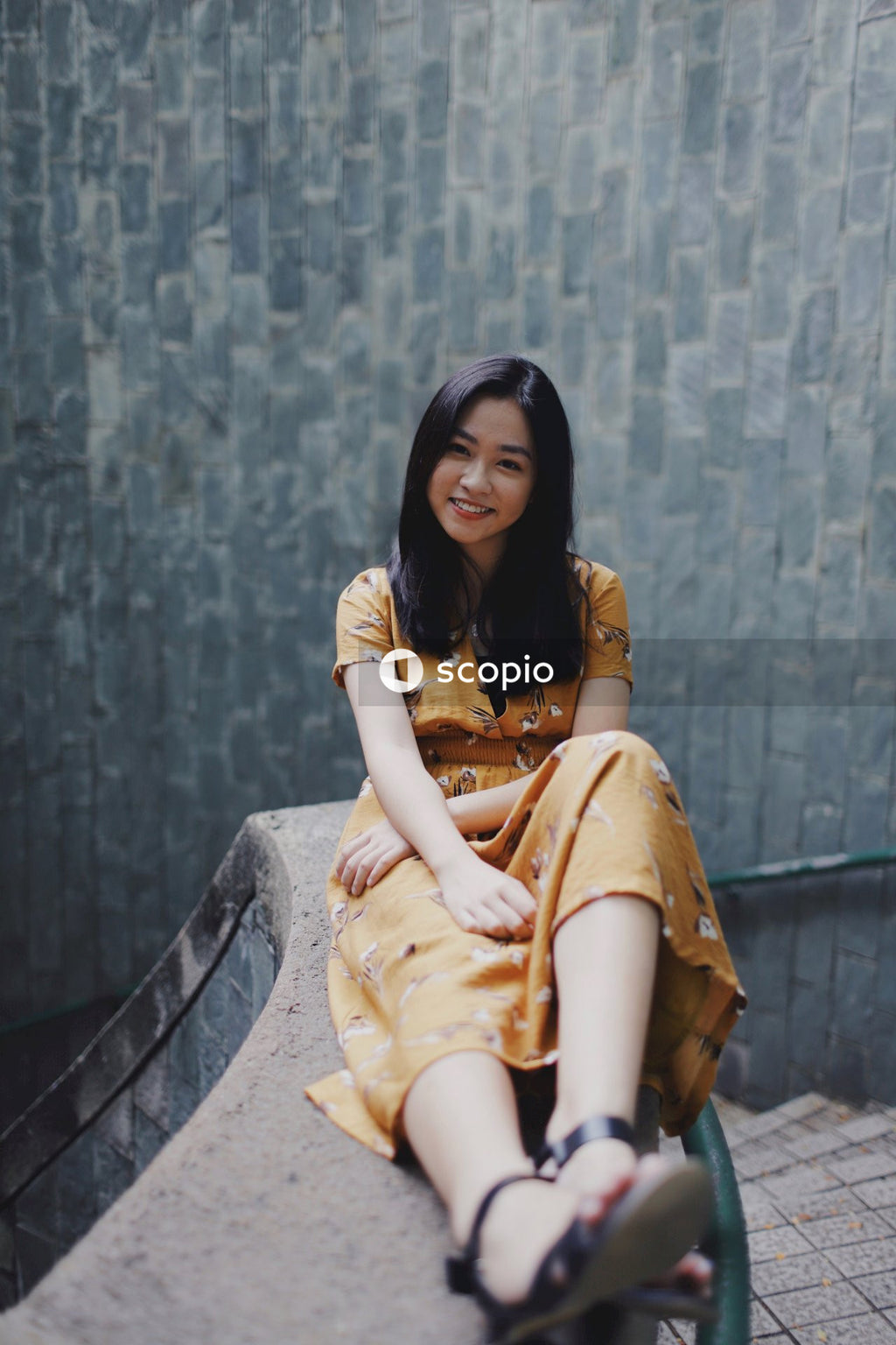Woman in orange dress sitting on stairs