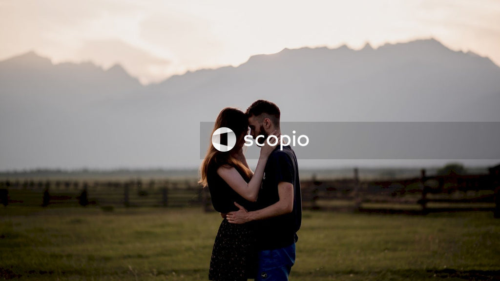 Man and woman hugging in green grass field