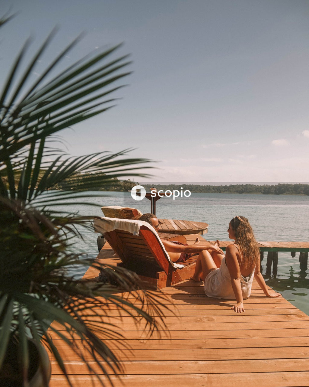 Couple sitting on jetty by lake