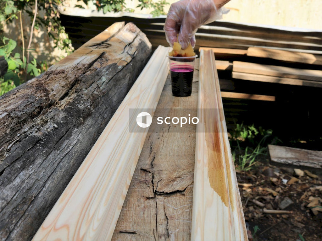 Black and red plastic bottle on brown wooden plank