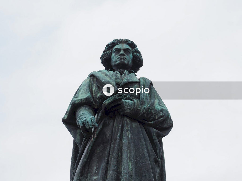 Black statue of man holding book