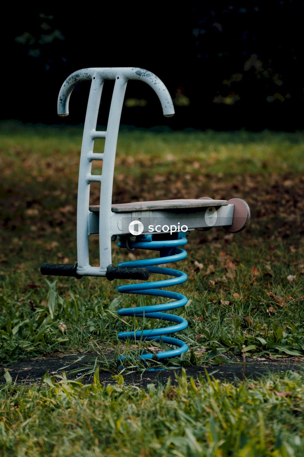 Blue and white metal tool on green grass