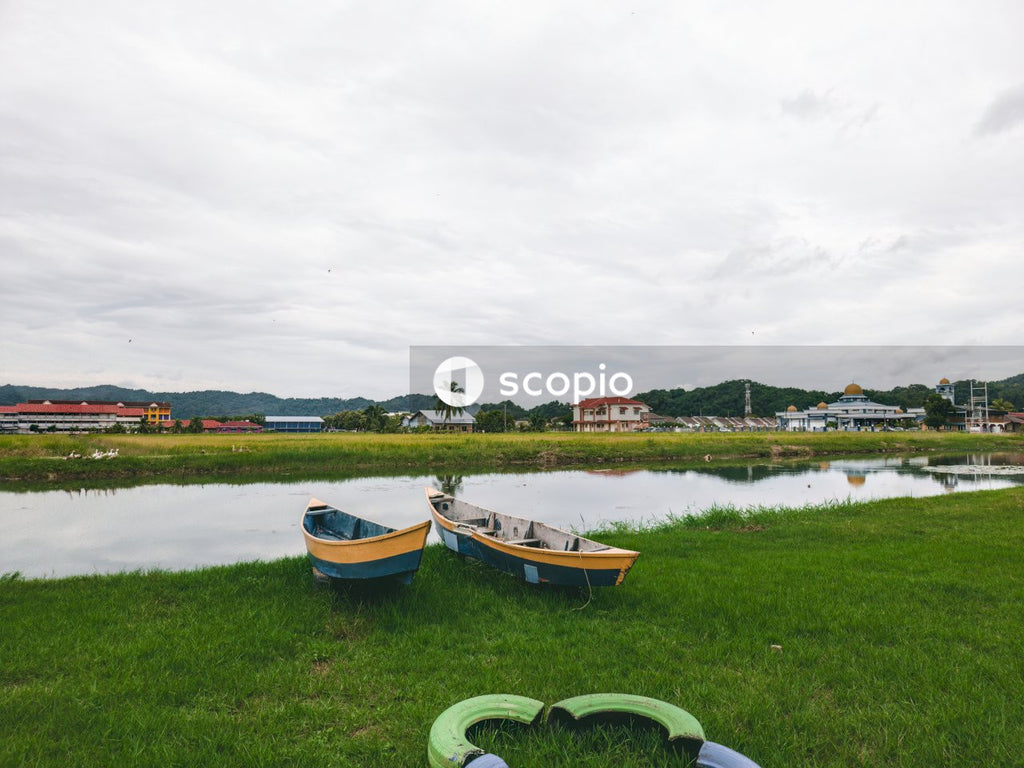 Blue and yellow boat on green grass field