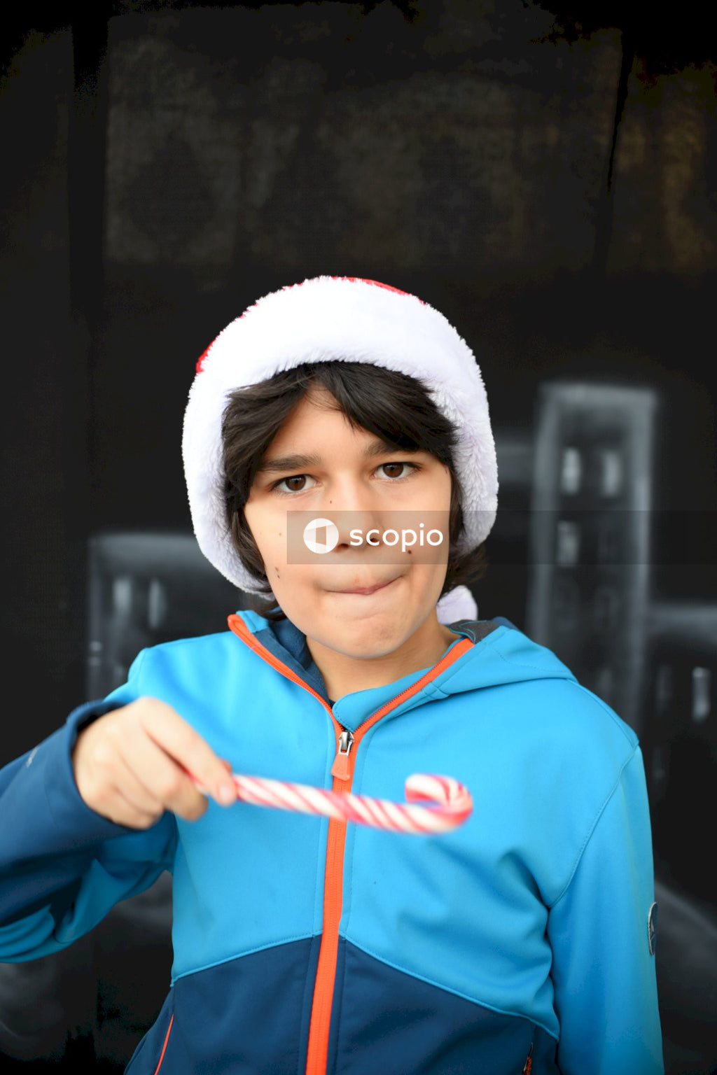 Boy in blue hoodie wearing white knit cap