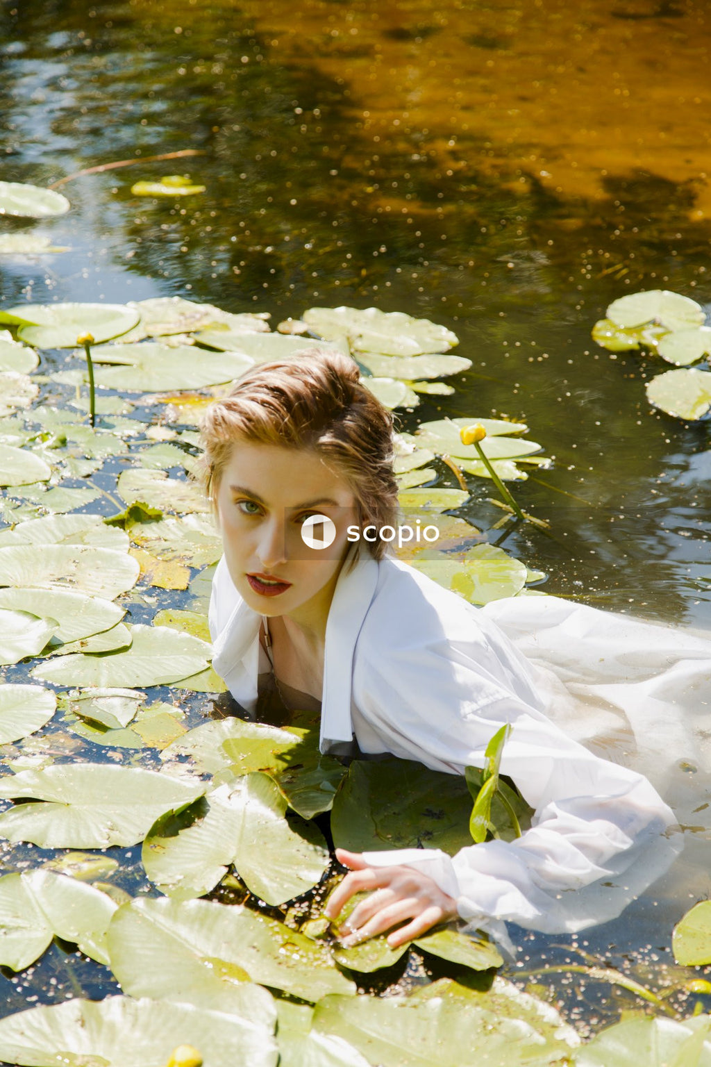 Boy in white jacket on water lily