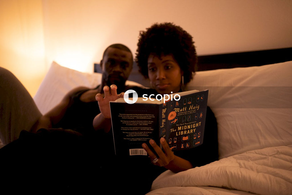 Couple sitting in bed reading book