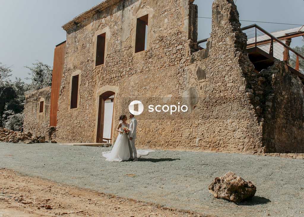 Bride and groom standing beside a broken building