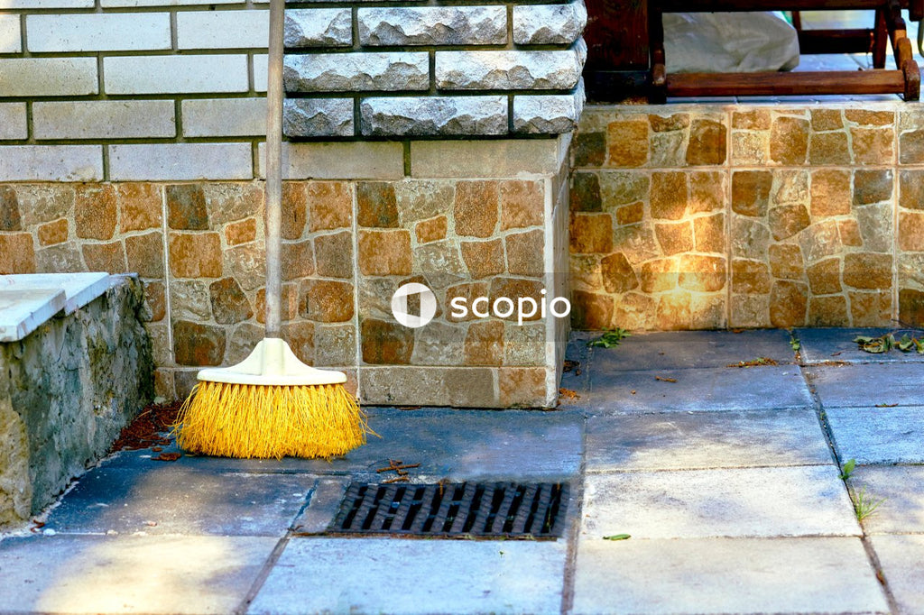 Broom leaning on brick wall