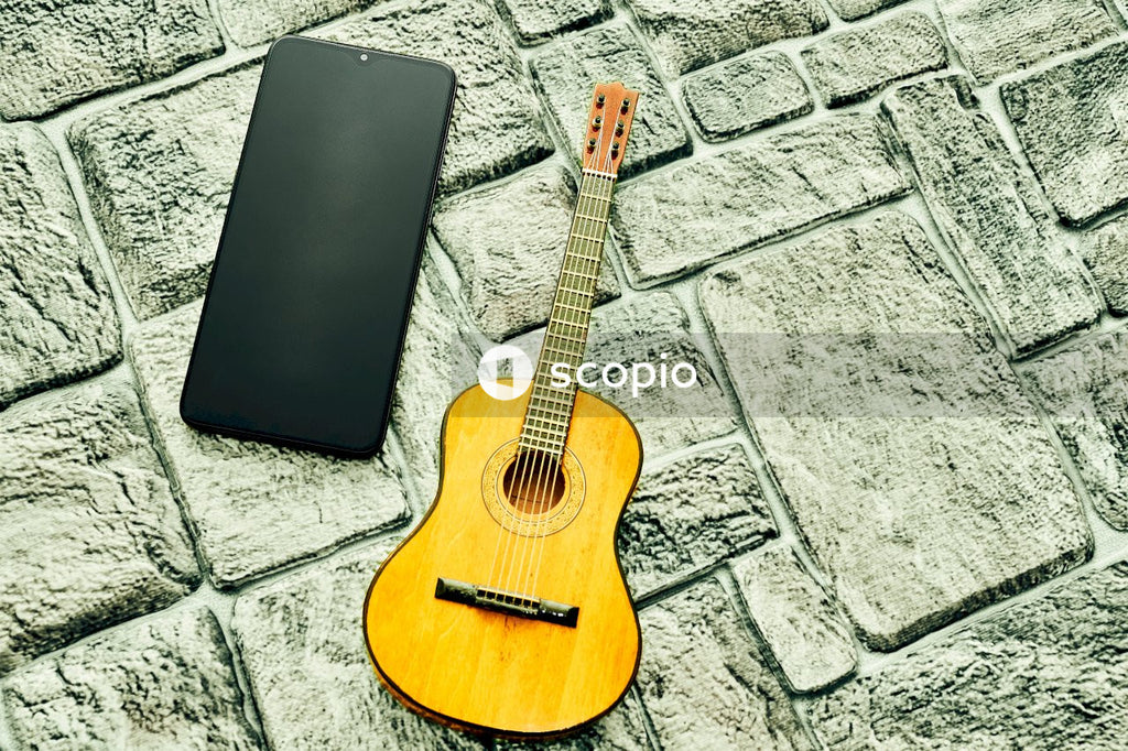 Brown acoustic guitar on gray concrete floor