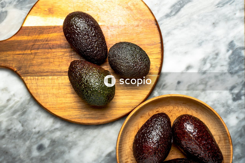 Brown and green round fruits on brown wooden round plate