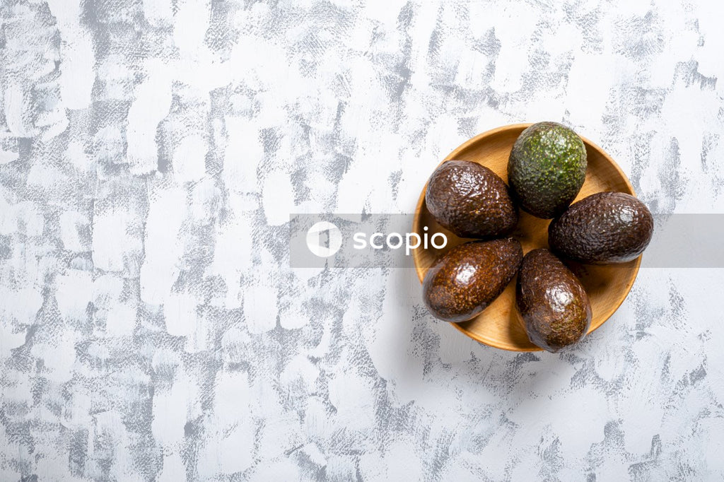 Brown and green round fruits on white textile