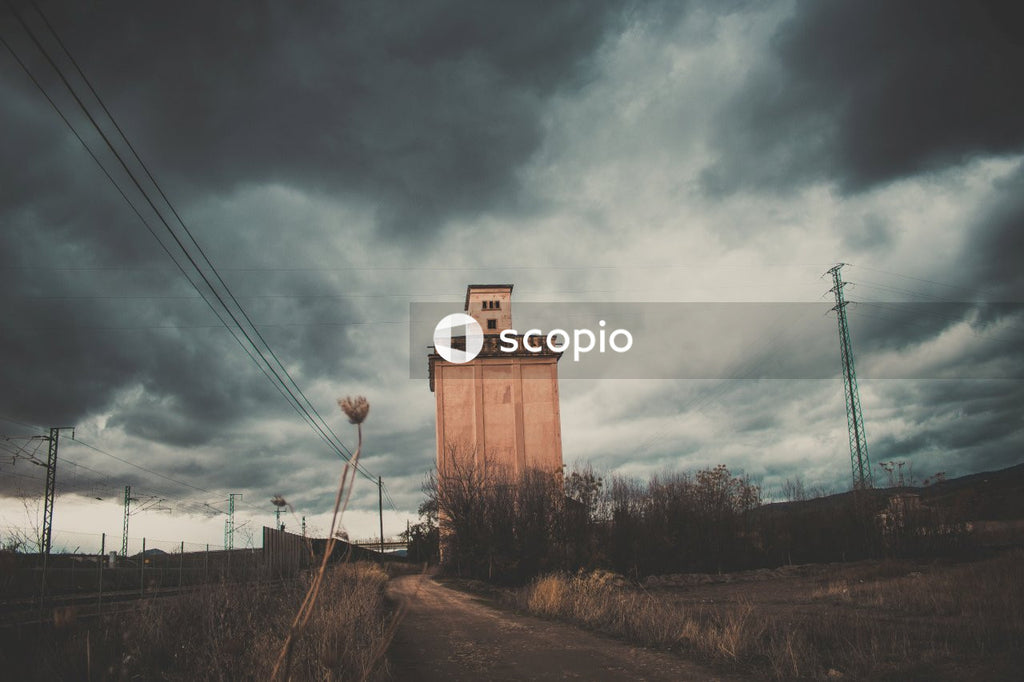 Brown concrete tower under cloudy sky