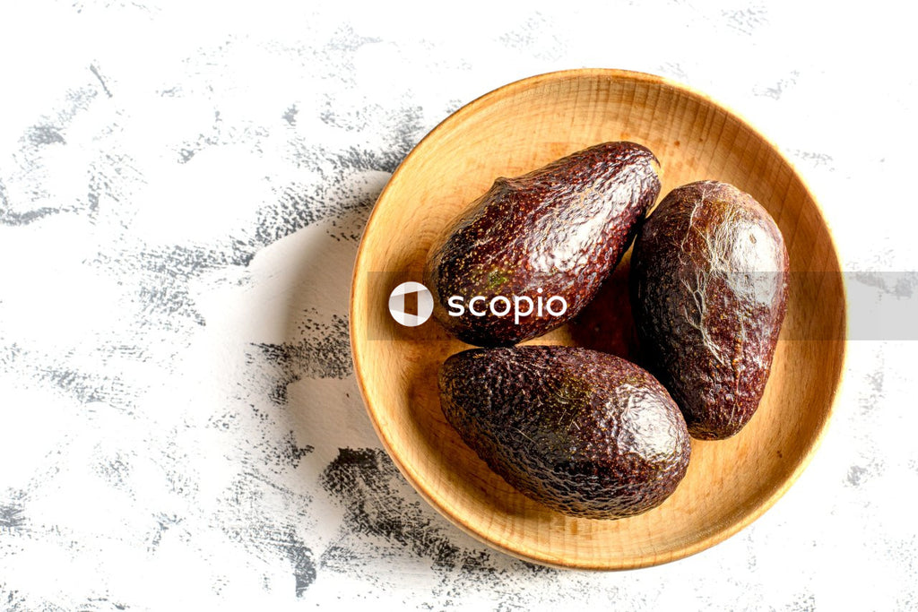 Brown round fruit on brown wooden bowl