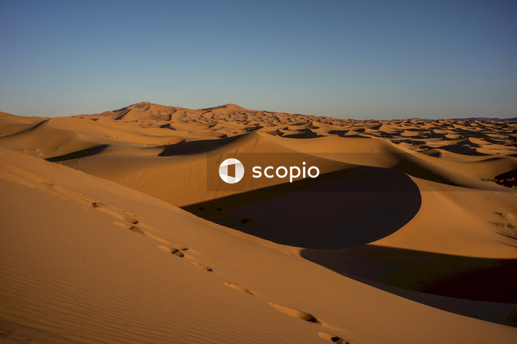 Brown sand dunes under blue sky