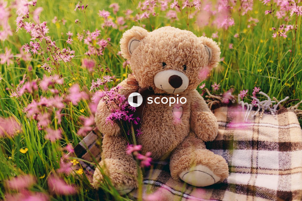 Brown teddy bear on purple and white plaid textile
