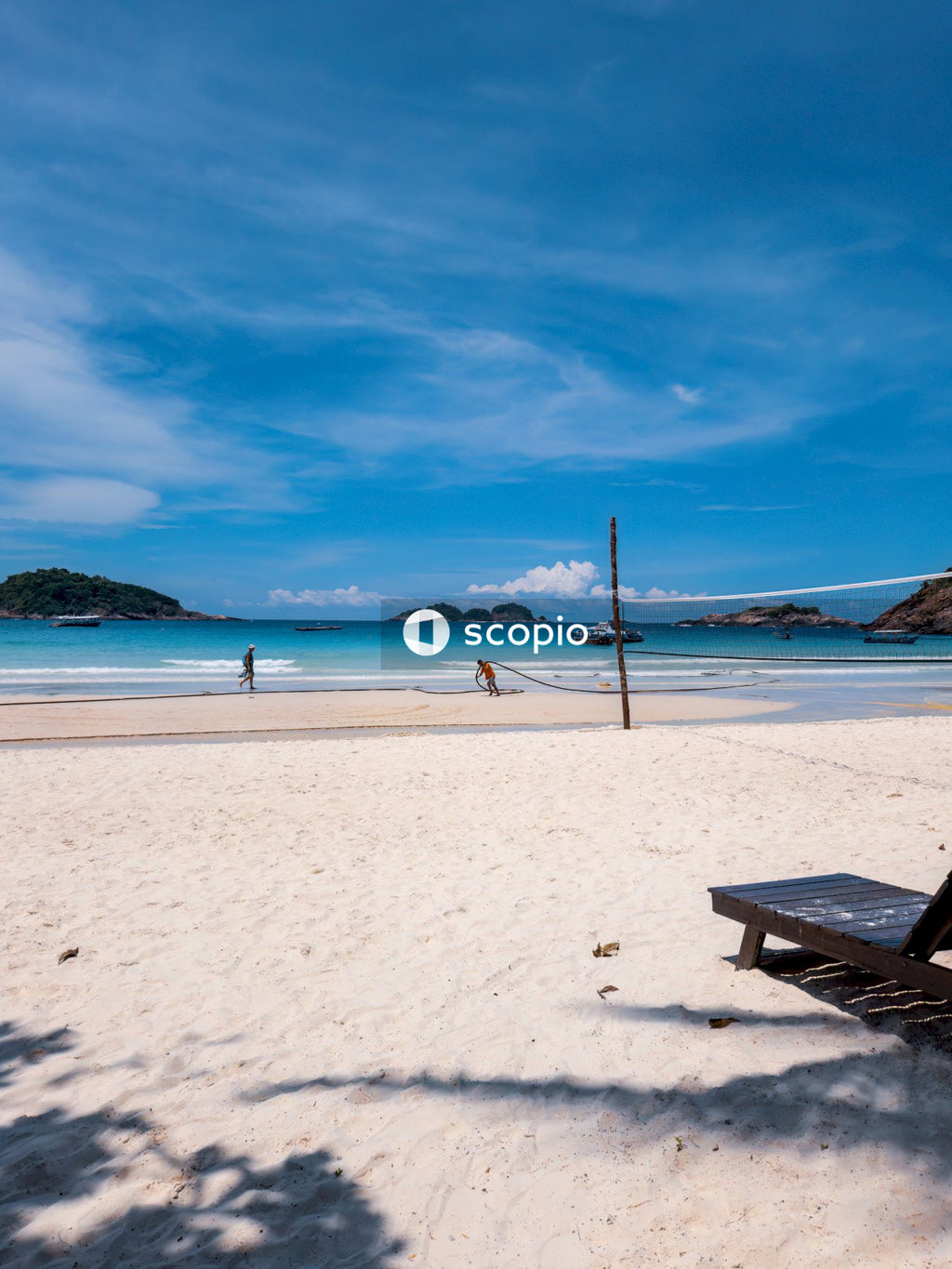 Brown wooden bench on white sand beach