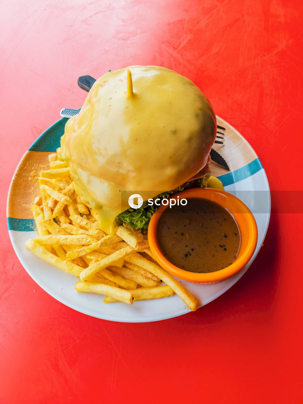 Burger and fries on white and red checkered plate