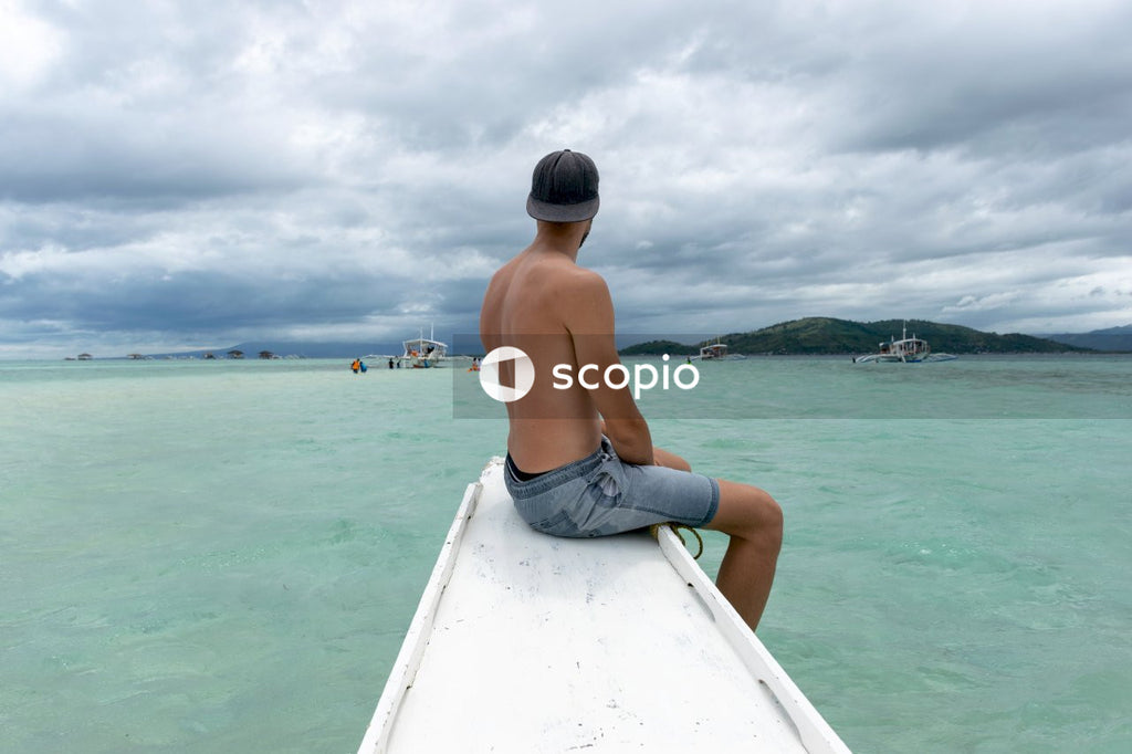 Shirtless man looking out onto the sea