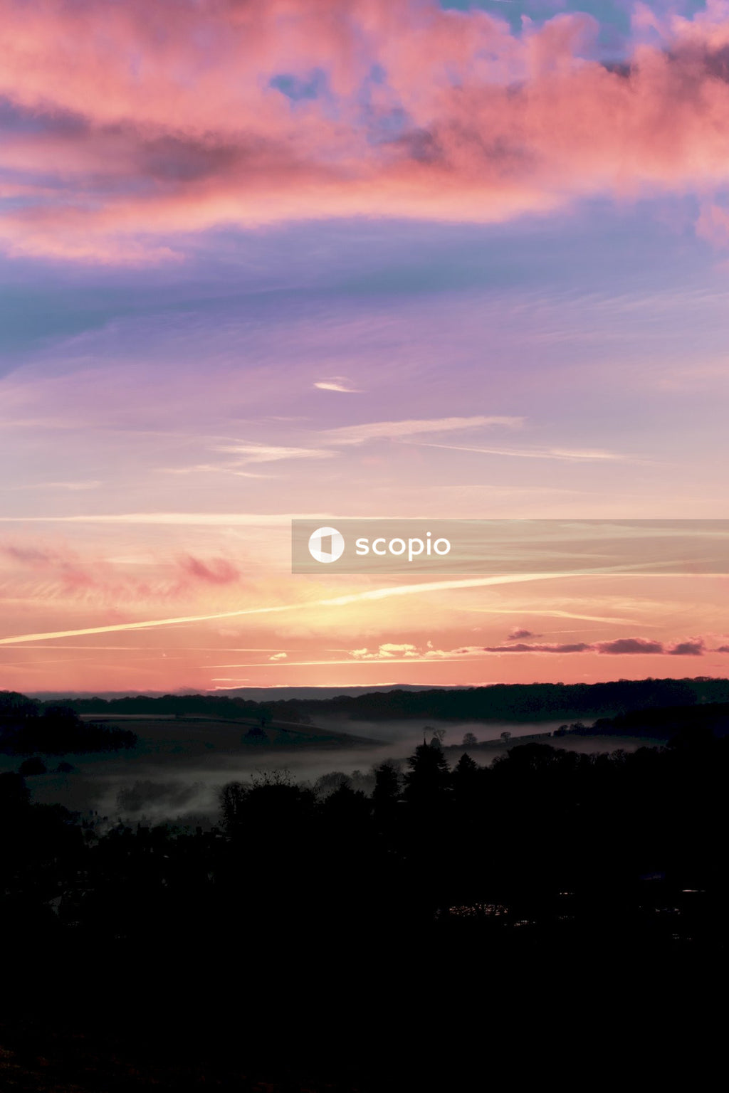 Foggy Landscape Illuminated by Warm Colors of Sunrise