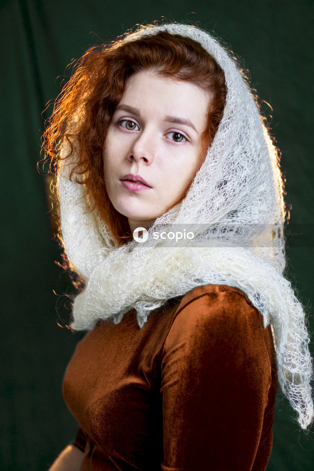 Woman in white scarf and brown shirt